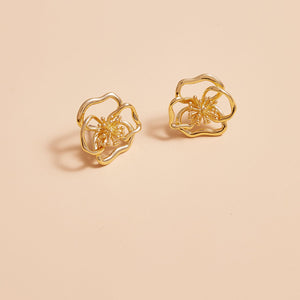 Gold Flower Hardware Stud Earrings on Tan Background