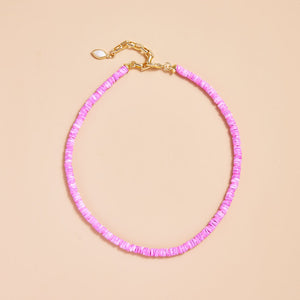 Pink Beaded Strand Necklace on Tan Background